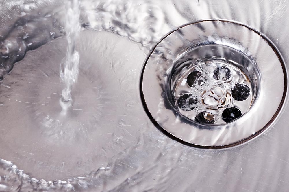 water being poured in sink drain