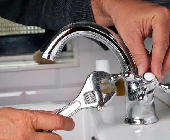 plumber tightening faucet